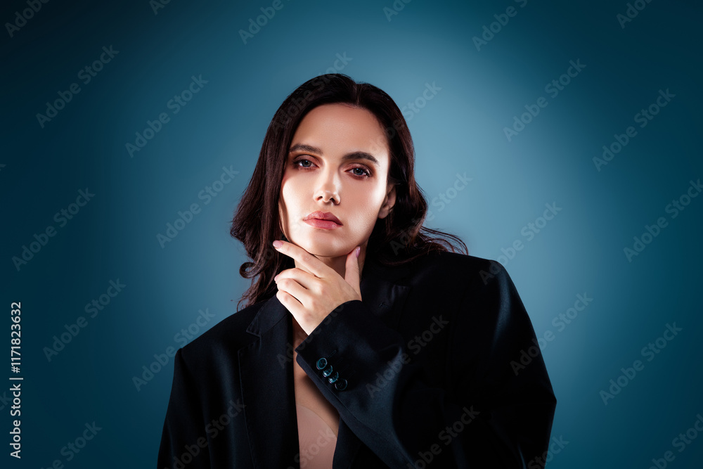 Elegant young woman in black jacket posing against blue gradient background Elegant young woman in black jacket posing against blue gradient background