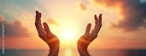 Silhouette hands reaching for sky at sunrise. Spiritual moment of prayer worship against warm sunset backdrop. Peaceful scene suitable for various religious spiritual concepts. Early morning