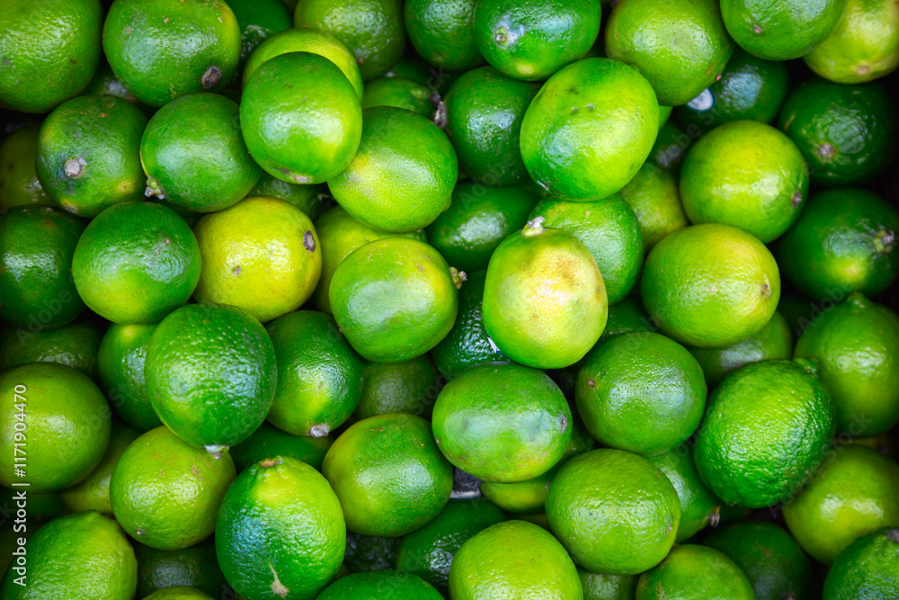 Many lime citrus fruits at a fruit market. Food background. Top view Many lime citrus fruits at a fruit market. Food background. Top view