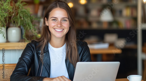 Australian woman in black leather jacket working with a laptop at library cafe