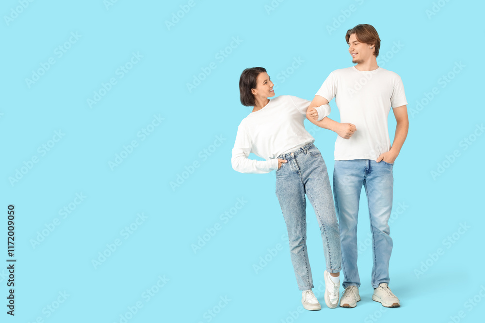 Young couple in jeans on blue background Young couple in jeans on blue background