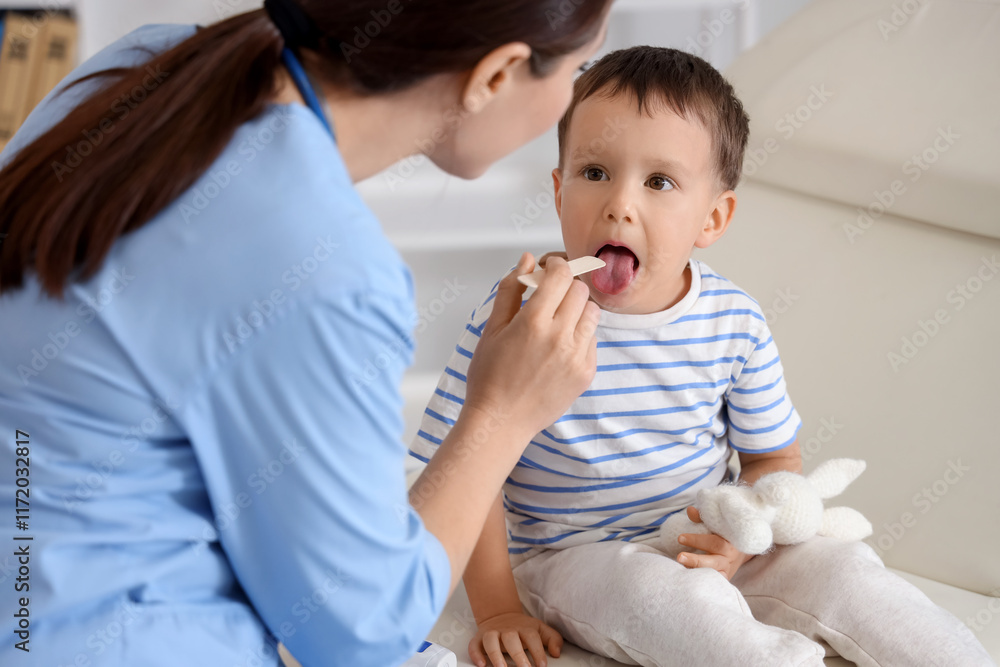 Female pediatrician checking little boy's throat in clinic Female pediatrician checking little boy's throat in clinic