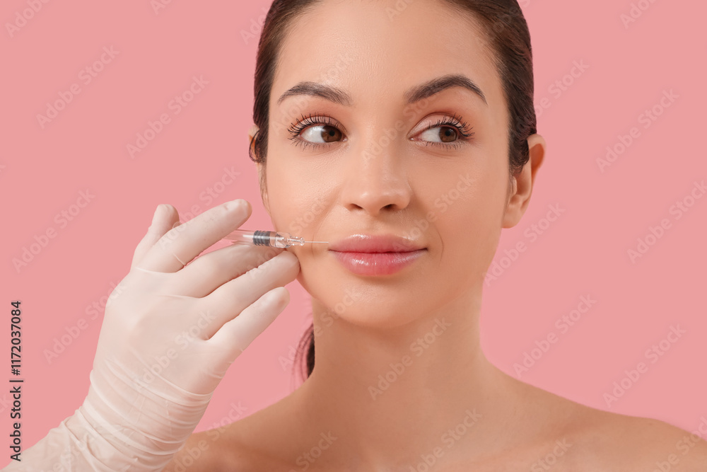 Beautiful young happy woman receiving lips injection on pink background Beautiful young happy woman receiving lips injection on pink background