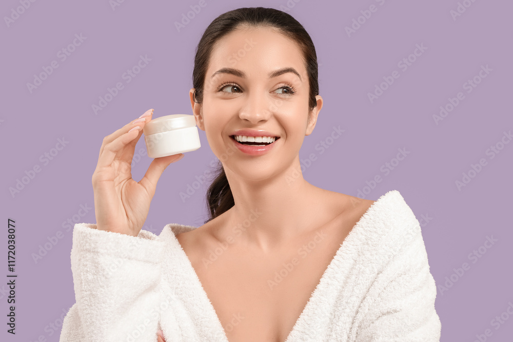 Beautiful young happy woman in bathrobe with jar of cream on purple background Beautiful young happy woman in bathrobe with jar of cream on purple background