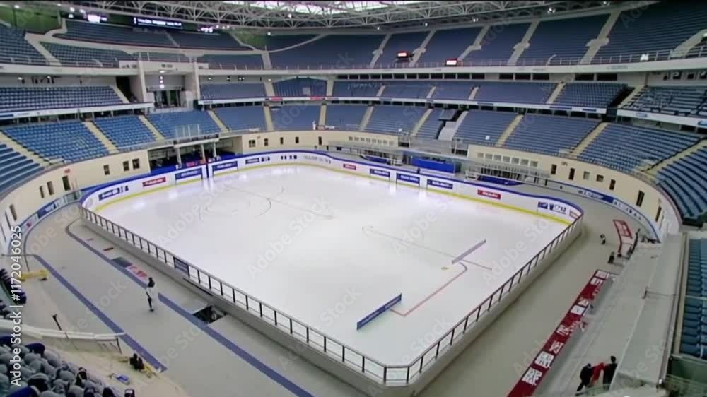 Empty hockey stadium with pristine ice rink and seating. Full view captures vast, quiet venue with no spectators or players, emphasizing the open space and arena details. Empty hockey stadium with pristine ice rink and seating. Full view captures vast, quiet venue with no spectators or players, emphasizing the open space and arena details.