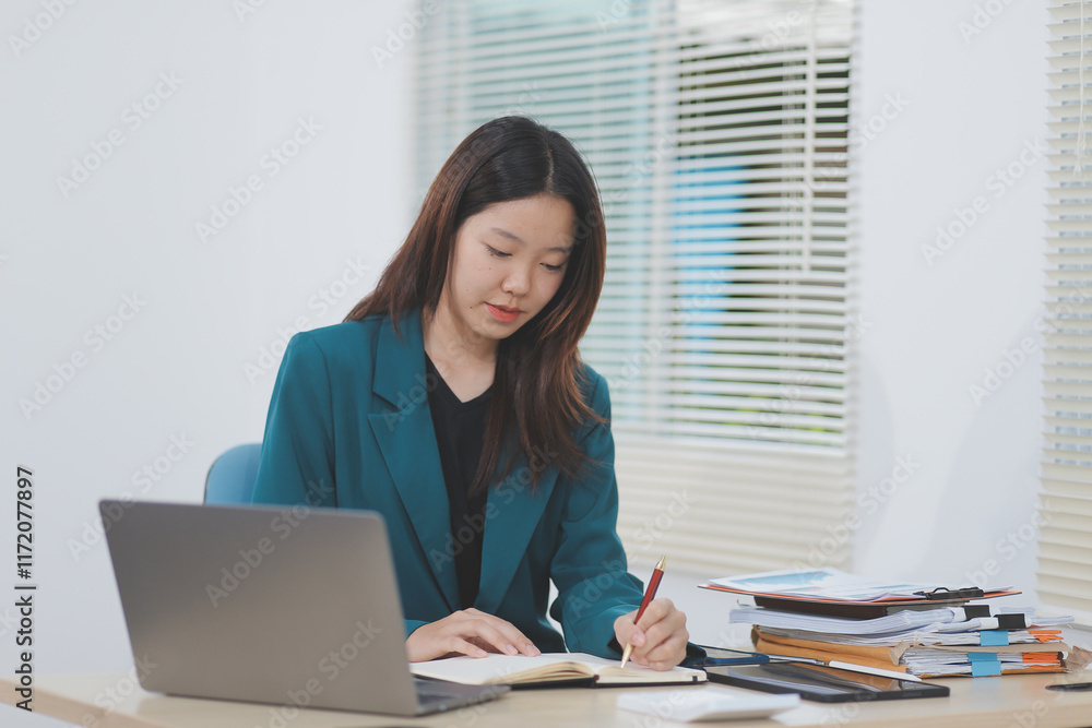 Asian professional businesswoman working on tablet computer in a corporate office Asian professional businesswoman working on tablet computer in a corporate office