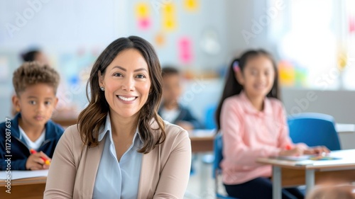 A smiling teacher sits in a classroom, engaging with students who are attentively focused on their work.