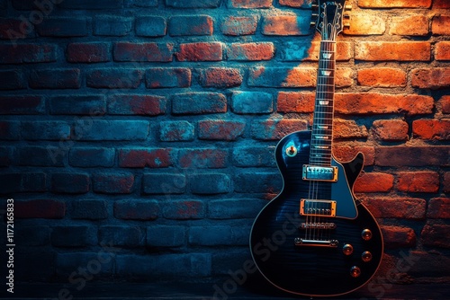 Two electric guitars leaning on a brick wall with moody lighting