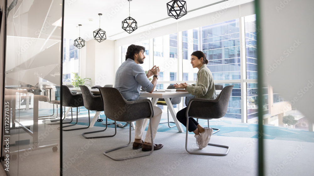 © fizkes - Two male and female coworkers talking at large conference table in contemporary office interior, meeting for teamwork, creative planning. Wide banner shot through glass doorway © fizkes - Two male and female coworkers talking at large conference table in contemporary office interior, meeting for teamwork, creative planning. Wide banner shot through glass doorway