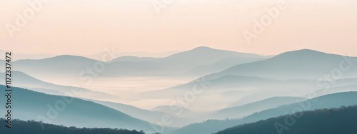 A tranquil view of a misty mountain landscape with layers of rolling hills fading into the distance, bathed in the soft light of dawn, Misty mountains scene