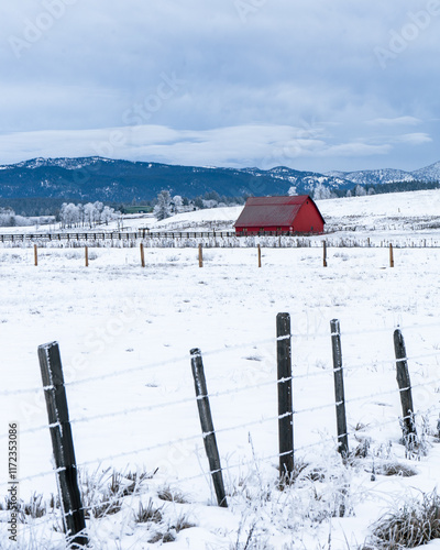 landscape in the mountains red barn in snow