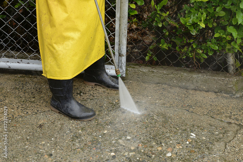 Outdoor pressure washing with high pressure water jet. The cleaning man washes the concrete. Professional pressure cleaning service concept. photo