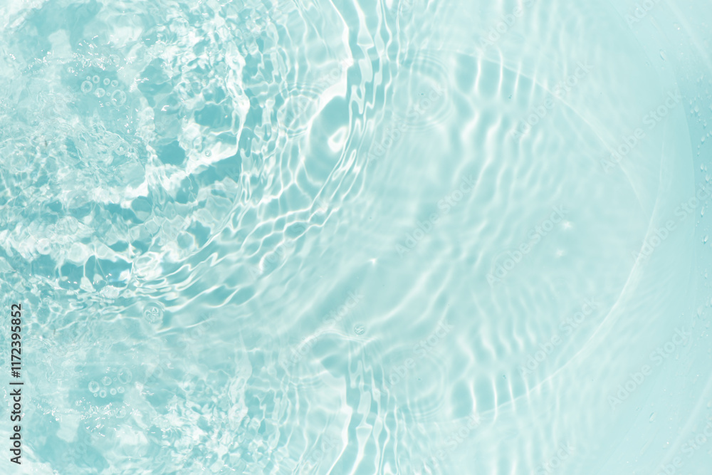 Obraz premium Blue water with ripples on the surface. Defocus blurred transparent blue colored clear calm water surface texture with splashes and bubbles. Water waves with shining pattern texture background.