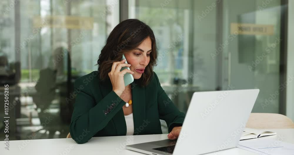 Businesswoman speaking on mobile phone and using laptop working seated at desk in contemporary office, discuss deal, receive or provide consultative support by phonecall. Workflow, communication, tech Businesswoman speaking on mobile phone and using laptop working seated at desk in contemporary office, discuss deal, receive or provide consultative support by phonecall. Workflow, communication, tech