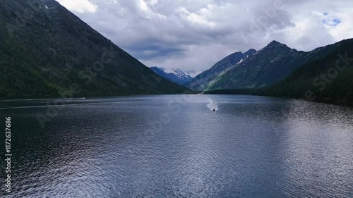 a boat sails on the Multinskoye lake in the Altai mountains in summer