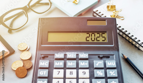 A calculator displays the year 2025