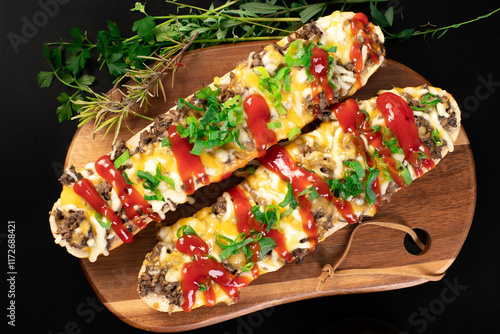 Toasted open-face sandwich made of a sliced baguette  topped with white mushrooms, cheese and ketchup, zapiekanki