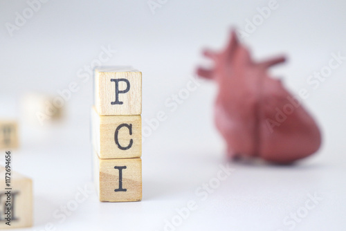 PCI word on wooden cubes isolated with heart on white background. Percutaneous Coronary Intervention concept of cardiology problems