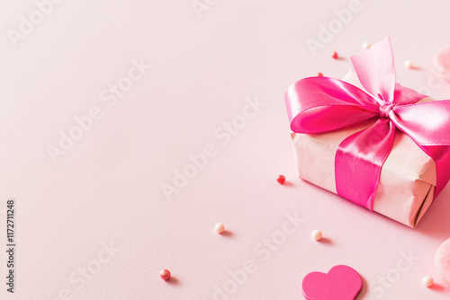 Pink hearts and gift box with ribbon on a light pink background