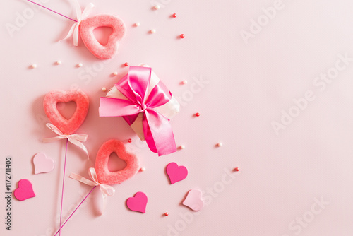Pink hearts and gift box with ribbon on a light pink background