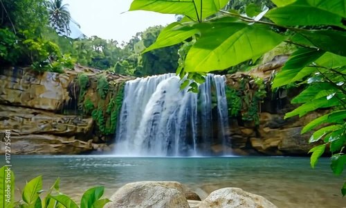 A serene waterfall surrounded by lush greenery and rocks.