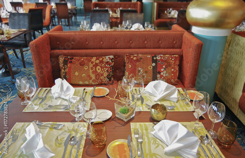 Formal and elegant Art Deco steak house speciality dining room restaurant onboard luxury cruiseship or cruise ship liner with set tables in classic interior design style and ceiling ambient lighting photo