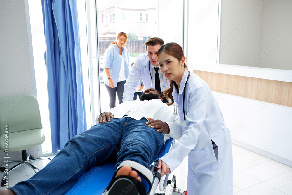 Obraz premium Doctors helping a patient with a broken leg lying in bed.