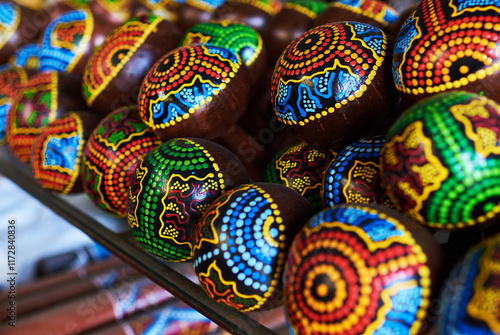 Colorful  souvenir background. Traditional Mexican maracas – handmade, bright colorful patterned musical instruments – sold in souvenir shops in tourist market. Sale of souvenirs. Selective focus.
