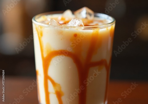 Delicious cold beverage with caramel drizzle served in a glass filled with ice
