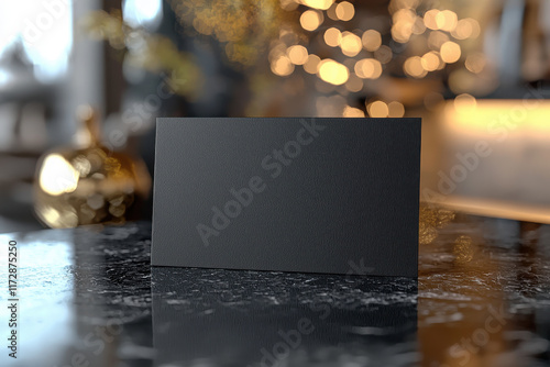 Black business card standing on marble table in blurred luxurious interior
