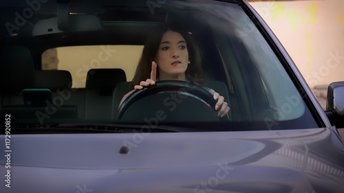 Obraz na płótnie Young woman hesitating and pointing finger up while driving car w salonie