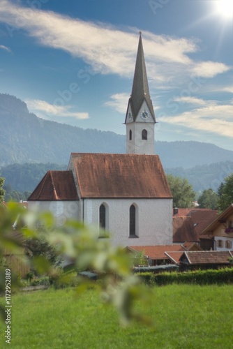 Kirche in Schwangau vor malerischer Bergkulisse photo