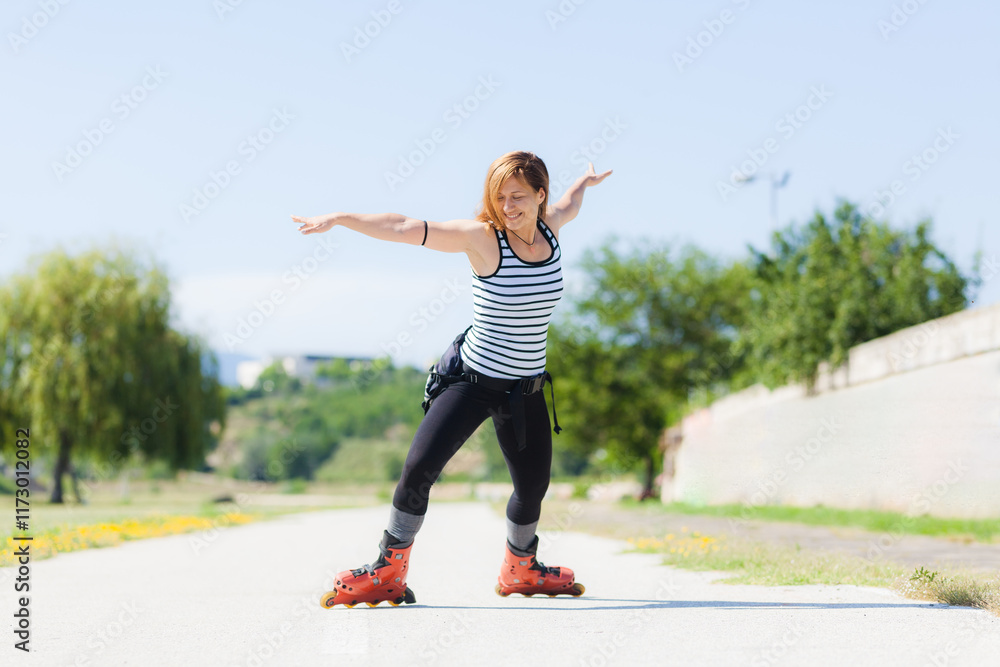 An active young woman rollerblading outdoors in a park, wearing a striped tank top and black leggings under a clear blue sky. An active young woman rollerblading outdoors in a park, wearing a striped tank top and black leggings under a clear blue sky.