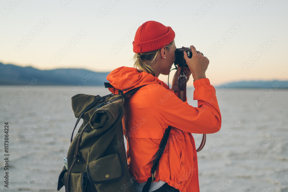 Female hiker taking photo in dry desert in USA Female hiker taking photo in dry desert in USA