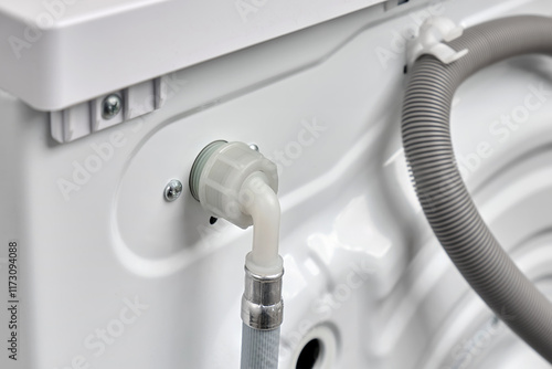 Top view  of a hose for connecting cold water to a washing machine in a house or apartment. Washer on back side.