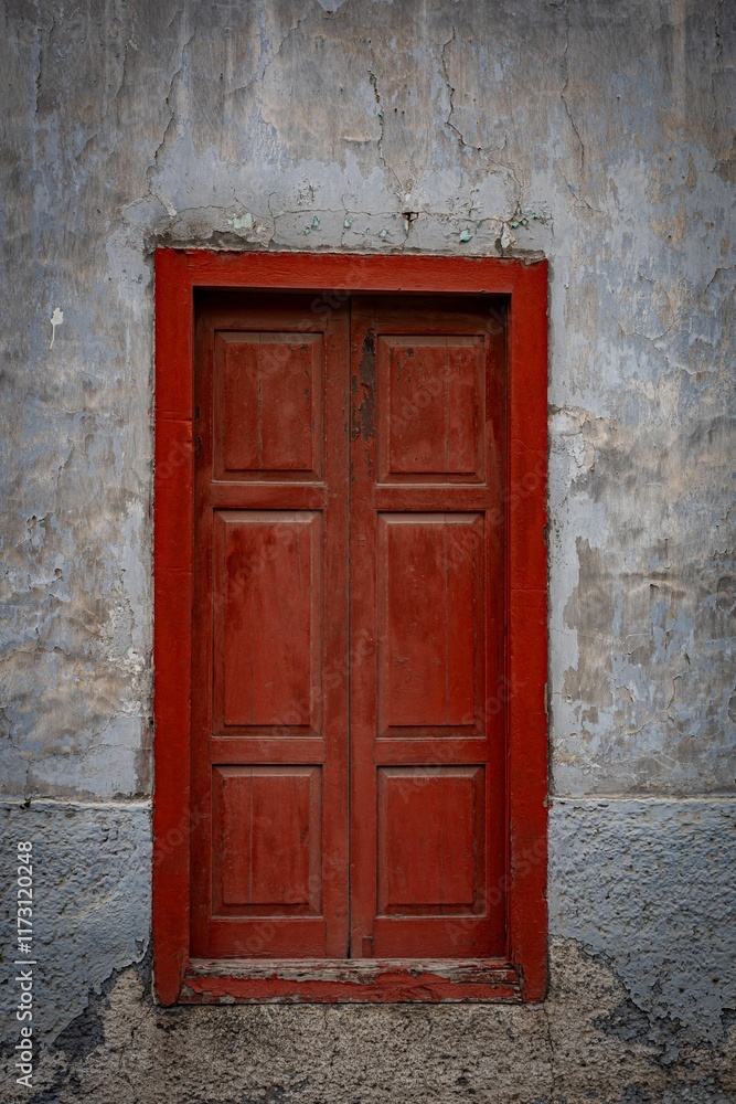 Weathered red wooden door in old concrete wall. Weathered red wooden door in old concrete wall.