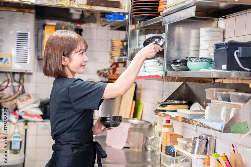 居酒屋の厨房で働くキッチンスタッフの女性 居酒屋の厨房で働くキッチンスタッフの女性