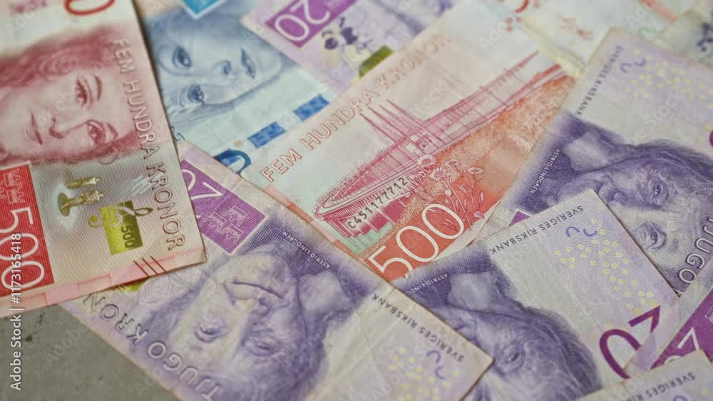 Closeup of various swedish banknotes displaying vibrant colors and different denominations of kronor spread out in a detailed arrangement. Closeup of various swedish banknotes displaying vibrant colors and different denominations of kronor spread out in a detailed arrangement.