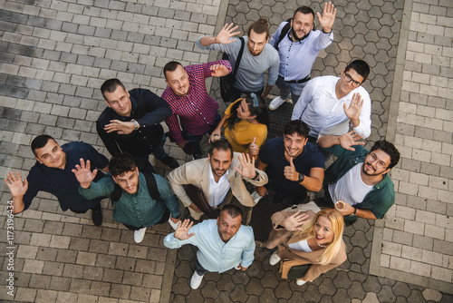 Fotografi Top view photo of a group of business people and colleagues standing together holding hands, looking towards the camera, symbolizing unity and teamwork