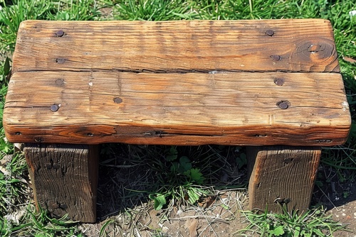 Rustic wooden bench resting on grass in a serene outdoor setting during daylight hours photo