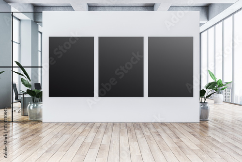 Fototapeta Naklejka Na Ścianę i Meble -  Three blank black posters mounted on a white wall in a modern office interior with glass partitions and wooden flooring. 3D Rendering