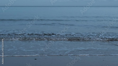 Calm easy sea with small waves breaking onto sandy beach at dusk in Sandbanks, Poole Dorset. With the sound of people and seagulls in the background. Pro Audio.