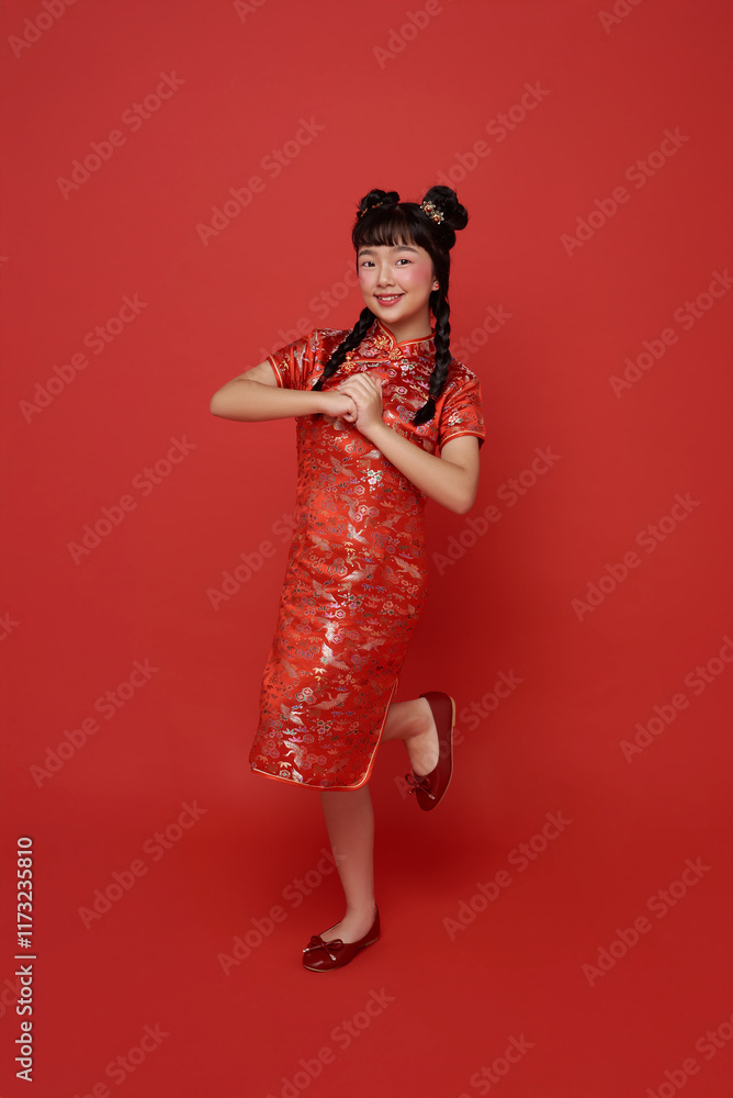 Happy Chinese new year. Asian children girl wearing traditional cheongsam qipao dress with gesture of congratulation isolated on red background. Happy Chinese new year. Asian children girl wearing traditional cheongsam qipao dress with gesture of congratulation isolated on red background.