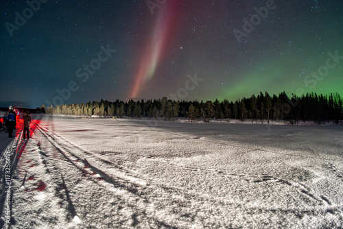 Snowmobile expedition Aurora Northern Lights in Lapland Inari Nellin Lake forest photo