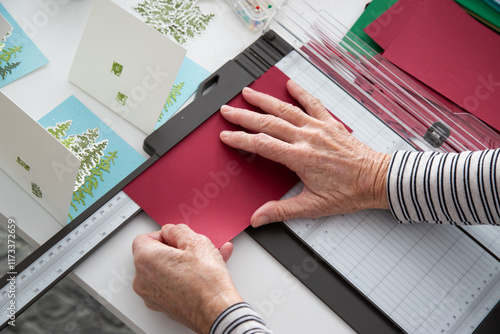 Overhead view of a woman sitting at a table making homemade Christmas cards photo