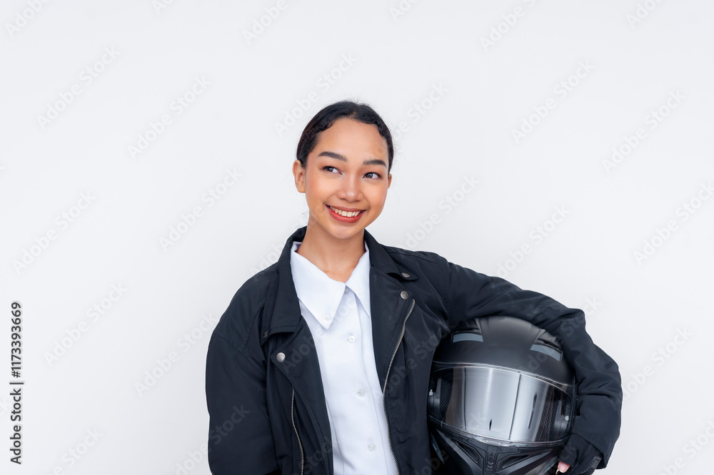 A young female motorcycle delivery driver feeling optimistic, looking to the left while posing with her helmet. Isolated on a white background. A young female motorcycle delivery driver feeling optimistic, looking to the left while posing with her helmet. Isolated on a white background.