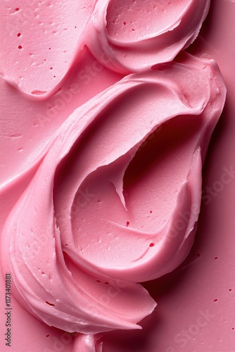 Creamy pink frosting swirled elegantly on a flat surface highlighting texture and color variations photo