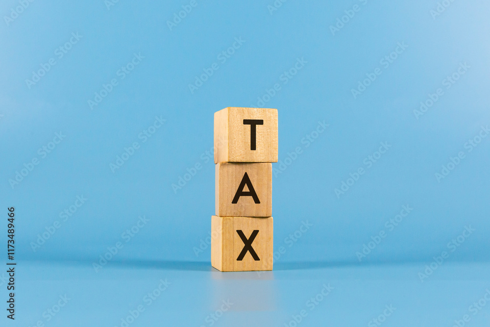 TAX text on wooden block with blue backgrounds. TAX text on wooden block with blue backgrounds.