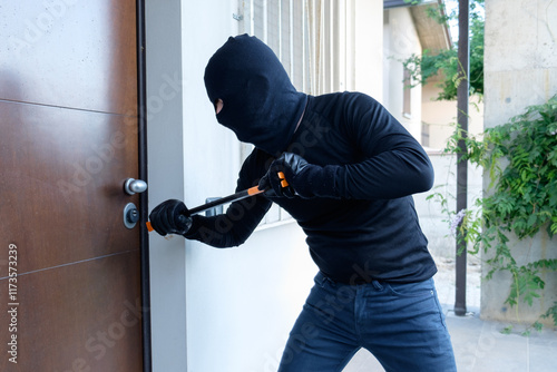 Burglar trying to force a door lock using a crowbar