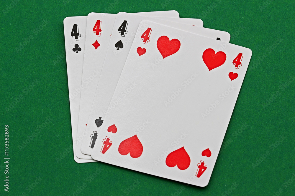 Obraz premium Close-up of playing cards showing four fours. Close-up of playing cards showing four fours, isolated on a green background.